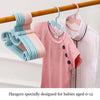 A set of adjustable baby clothes hangers in various pastel colors pink and blue hanging on a wooden rod.