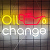 Neon sign spelling out Oil change in yellow and red lights against a dark grid background.