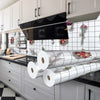 A kitchen splashback featuring silver corrugated rolls and floral accents on a white tiled wall.