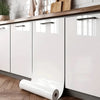 White peel-and-stick vinyl wallpaper installed on kitchen cabinets with wooden countertop and cutting boards