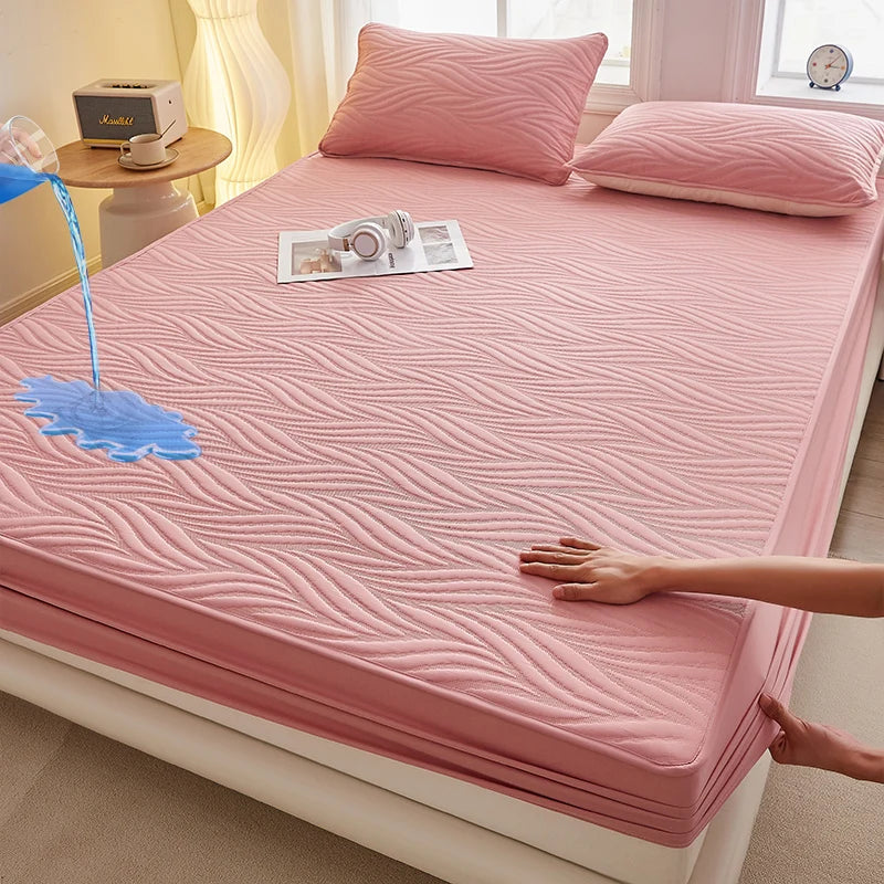 A pink floral waterproof fitted mattress protector is shown on a bed, with a hand touching the fabric.