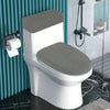 A white toilet with a gray fleece seat cover and matching lid and tank covers in a bathroom setting.