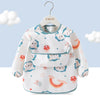 A white children's waterproof long sleeve feeding bib with a catch pocket featuring cute animal and food patterns.