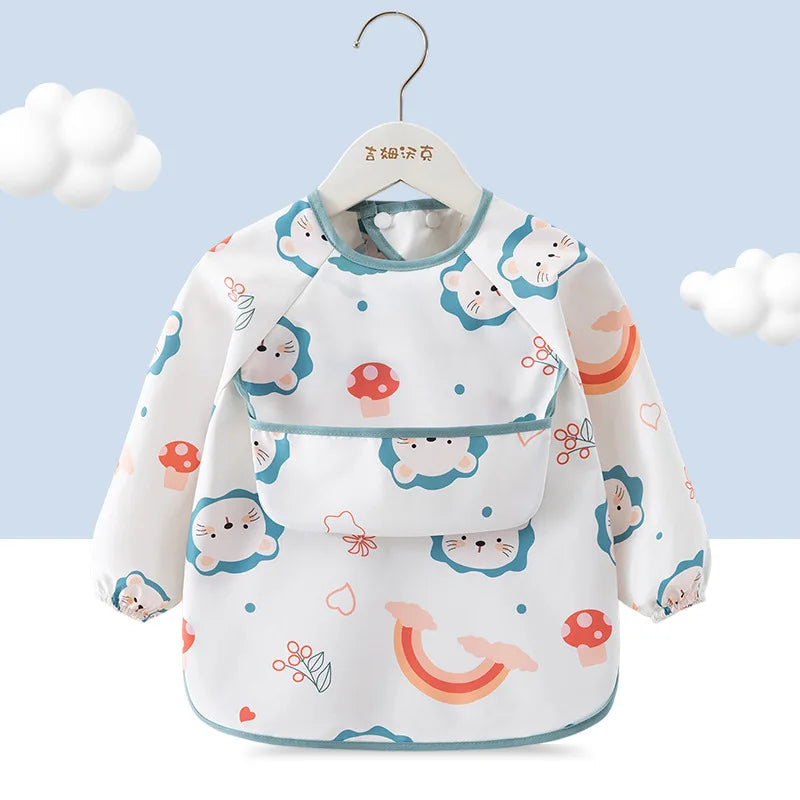 A white children's waterproof long sleeve feeding bib with a catch pocket featuring cute animal and food patterns.