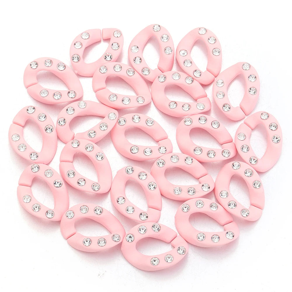 A set of twenty pink acrylic jewelry connector clasps with crystal accents arranged on a white background.