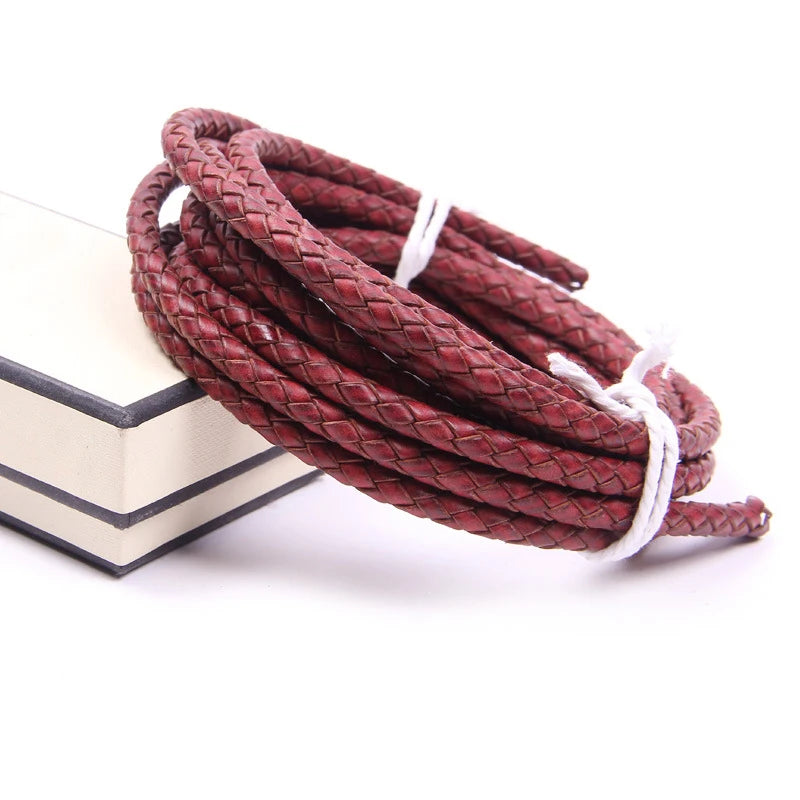 A coil of genuine braided leather cord in a reddish-brown color with white ends.