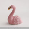 A pink ceramic swan figurine with a gold beak, shown against a white background.