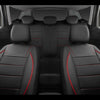 A full set of black leather car seat covers with red stitching shown in the rear interior of a vehicle.