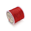 A spool of red nylon macramé cord for jewelry making with Chinese text labeling.