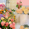 A close-up of colorful chenille craft stems in various shades of pink, yellow, and orange arranged in floral bouquets.