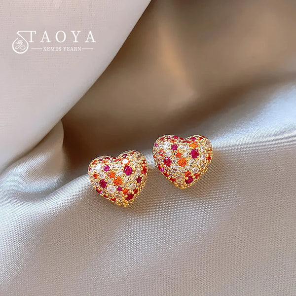 Boucles d'oreilles à clous en forme de cœur délicates avec des pierres multicolores roses, oranges et rouges.