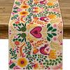 A table runner featuring a vibrant floral pattern in pink, yellow, and green for a Day of the Dead Mexican Fiesta.
