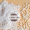 White decorative stone pebbles measuring 2-4mm in size, displayed on a light background.