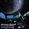 A car interior showing a USB starry sky light projector mounted on the ceiling, illuminating the cabin with stars.
