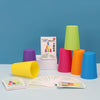 A set of colorful plastic cups and matching cards for a stacking game displayed against a blue background.