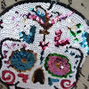 A white skull embroidered patch made of iridescent sequins and colorful thread for DIY clothing.