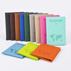 A collection of colorful passport holders in various shades including black, brown, blue, green, and pink.