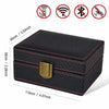 A black carbon fiber Faraday box with a gold-colored latch, shown from the top and side.