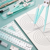 A complete geometry drawing set featuring a compass, protractor, and rulers laid out on a white sheet of paper.