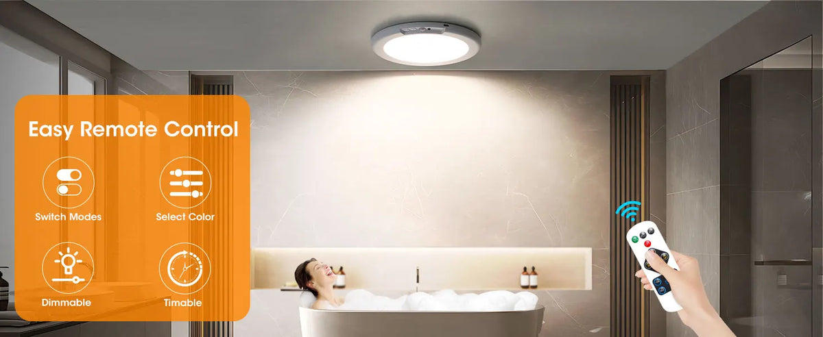 A hand holds a remote control while a person relaxes in a bathtub under an LED ceiling light.