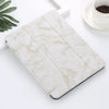 A white marble patterned iPad Pro case with a built-in pencil holder resting on a white surface.