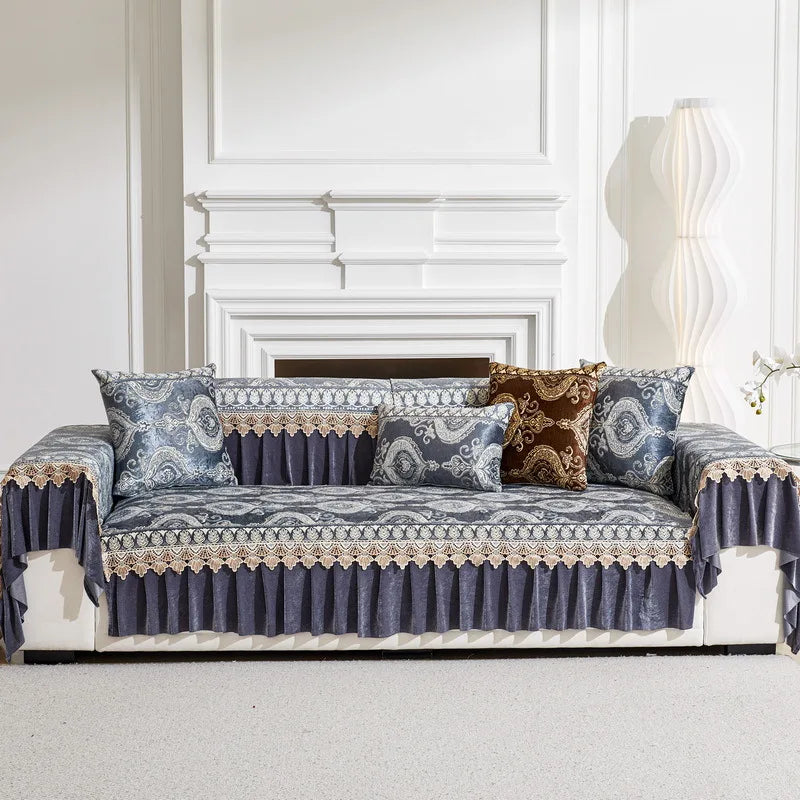 A navy blue patterned sofa cover with quilted protection displayed in a bright room.