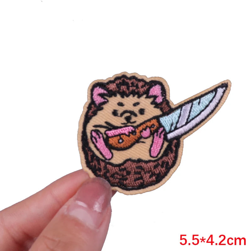 An embroidered patch featuring a cartoon animal face with pink ears and orange paws.