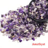 A pile of purple and white amethyst crystal stone chips in a black bowl.