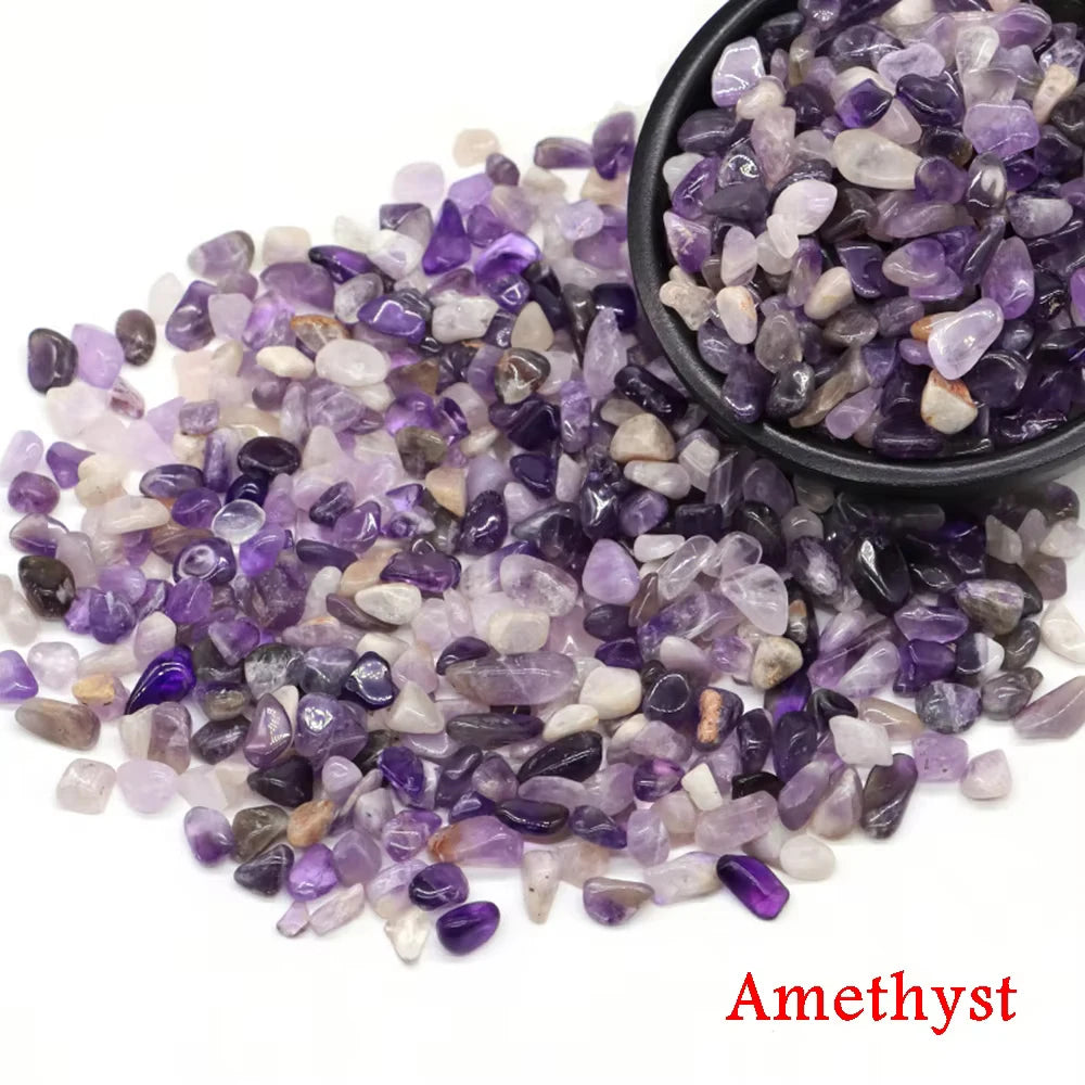 A pile of purple and white amethyst crystal stone chips in a black bowl.