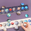 A wooden solar system puzzle featuring planets like Earth, Mars, Jupiter, Saturn, Uranus, and Neptune arranged on a purple ba