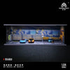 A 1:64 scale miniature garage diorama kit featuring two cars under lighting.
