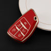 A red durable TPU car key fob cover with a gold trim rests on a white plate.
