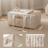 A beige floral diaper organizer bag with multiple compartments and a handle, shown on a light carpet.