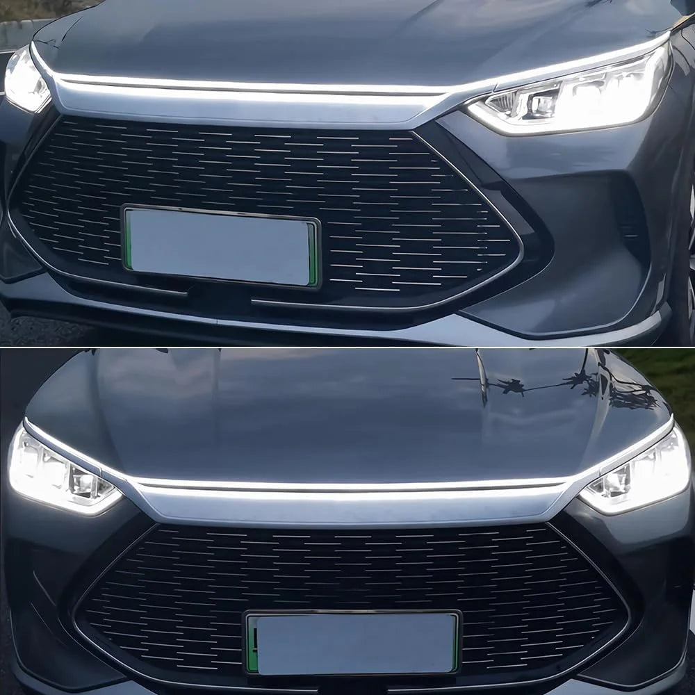 Close-up of a car's front grille and headlight with an LED light strip installed on the hood.