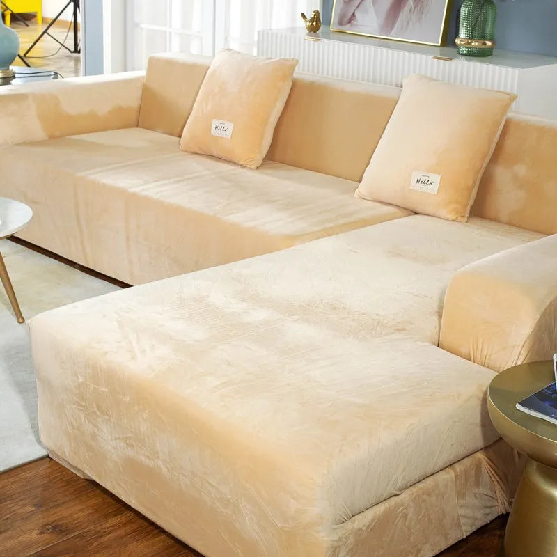 A beige plush velvet elastic sofa cover is shown on an L-shaped sofa, featuring decorative pillows.