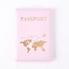 Pinkes Reisepasshülle mit goldenen Lettern und Weltkarten-Design.