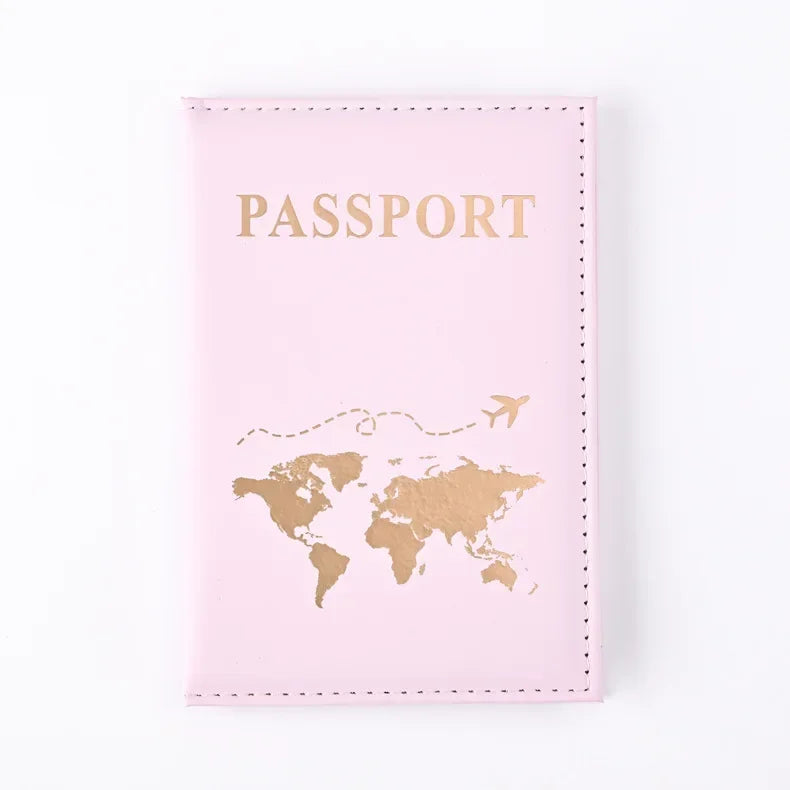 Pinkes Reisepasshülle mit goldenen Lettern und Weltkarten-Design.