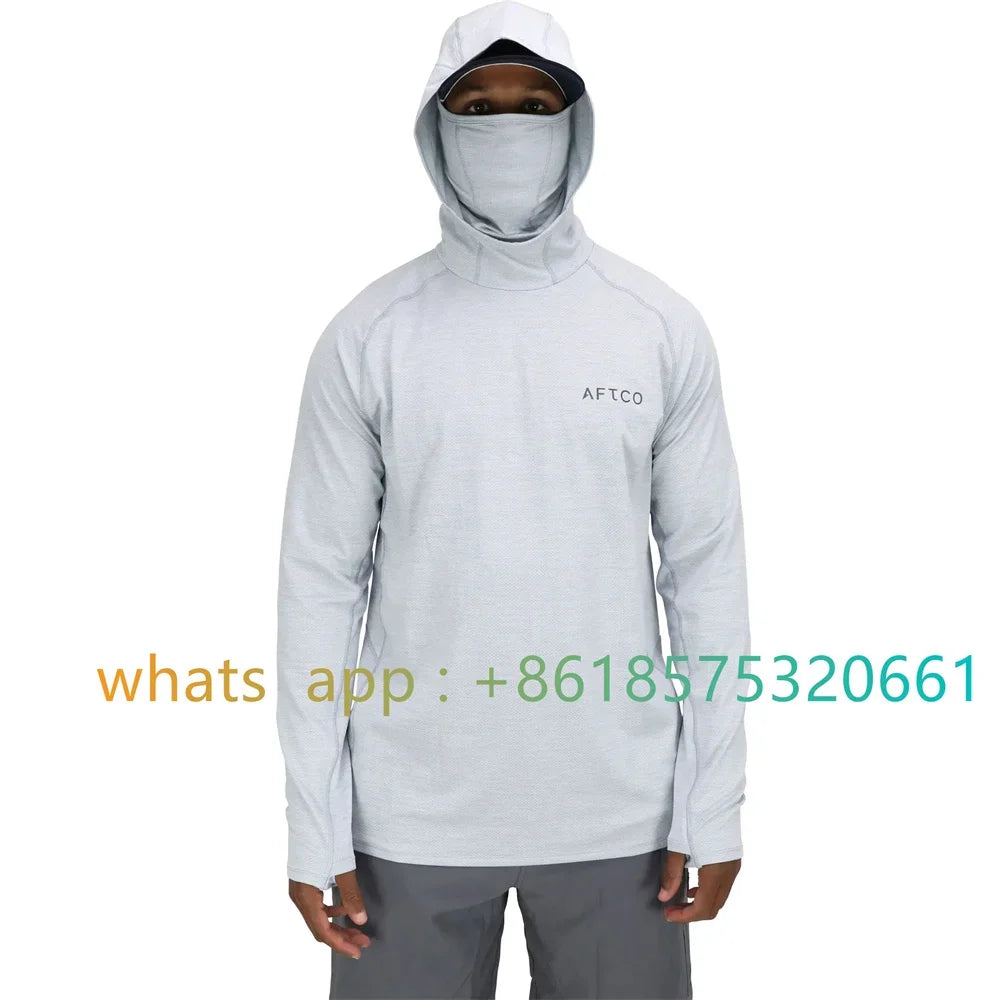 Un hombre vistiendo una camisa de manga larga gris claro con capucha y cubrebocas.