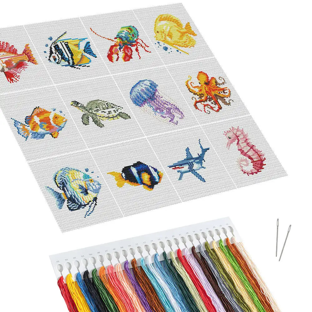 A cross stitch kit set featuring twelve colorful sea life designs on a gray fabric square with embroidery floss spools.