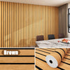Vertical wood grain wallpaper in brown tones used as a feature wall in a modern living room.