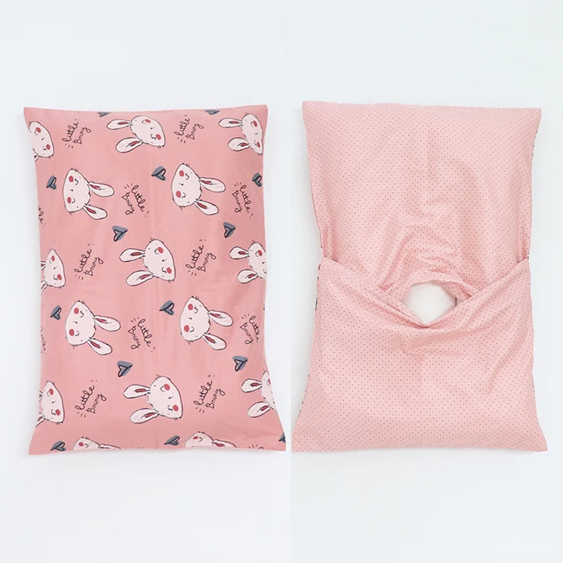 A pink soft cotton baby pillowcase featuring a repeating cartoon bunny design.