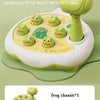 A small green frog toy with multiple eggs, a hammer, and a frog chassis are shown on a green background.