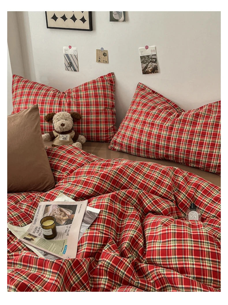 A close-up of a red and green plaid duvet cover set with matching pillows and bedding on a bed.