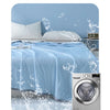 A light blue quilt being washed in a machine, emphasizing its durability and colorfastness.