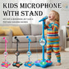A child is holding a portable karaoke microphone with a stand and light effects on the base.