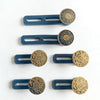 Six brass button waist extenders with dark blue plastic arms and circular heads.