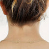 A close-up of a gold-plated necklace extender chain with lobster clasps against a person's neck.