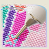 A silver metal dot drill pen tip used for painting patterns and dot drills on a colorful surface.