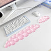 A pink cloud-shaped ergonomic wrist rest set for a keyboard and mouse is displayed on a white desk.