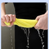 A yellow velvet cleaning cloth absorbs water thoroughly, dripping into a bowl of water.